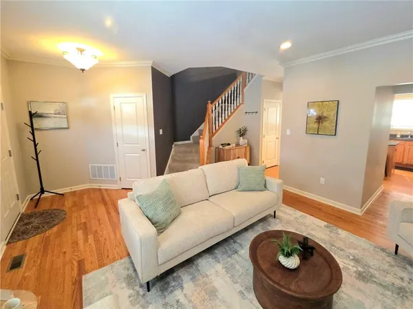 a living room with furniture and a wooden floor