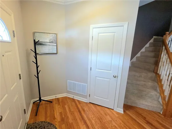 a view of a hallway with wooden floor and staircase