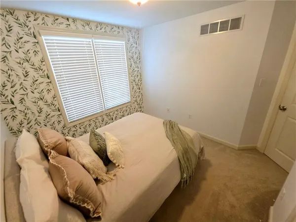 a bed sitting in a bedroom next to a window