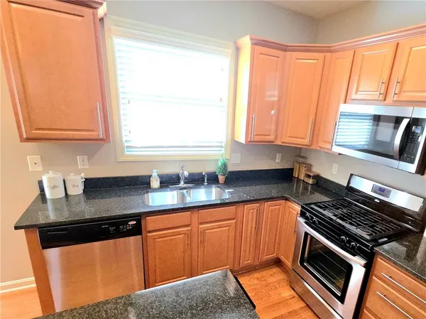 a kitchen with granite countertop a stove sink and cabinets