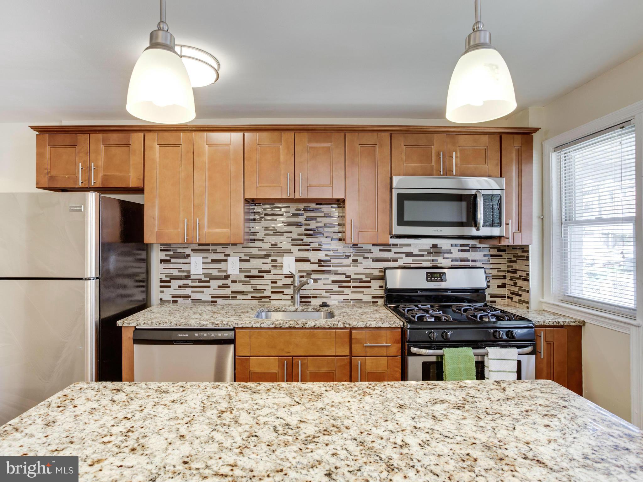 4400 Eldone Road Baltimore, MD 21229 - Photo 12 of 30 a kitchen with stainless steel appliances granite countertop a sink refrigerator stove and microwave