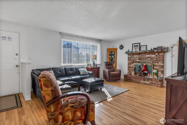 a living room with furniture a flat screen tv and a fireplace