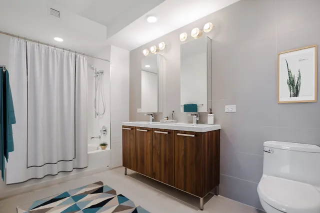 a bathroom with a sink vanity mirror and toilet