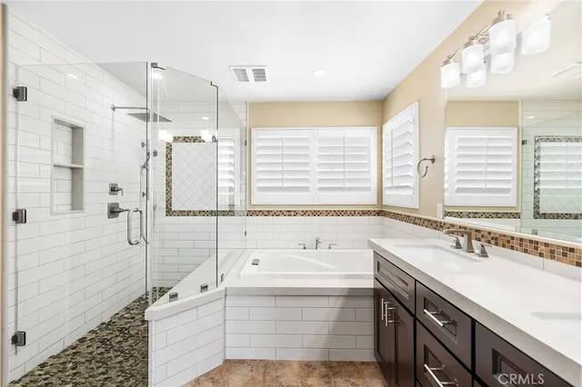 a bathroom with a tub sink and mirror