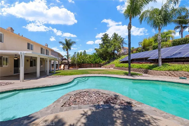 a view of a house with swimming pool and a yard