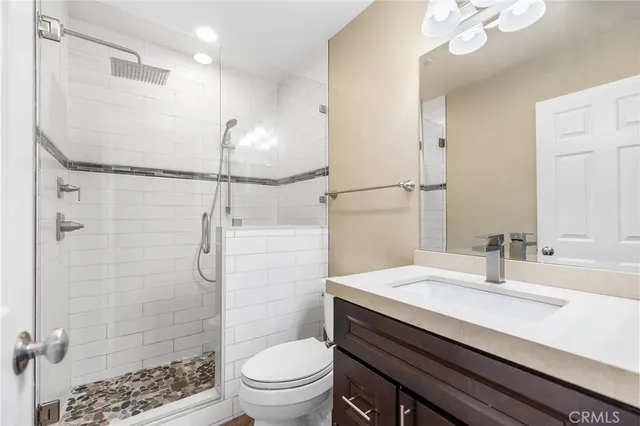 a bathroom with a sink toilet vanity and shower