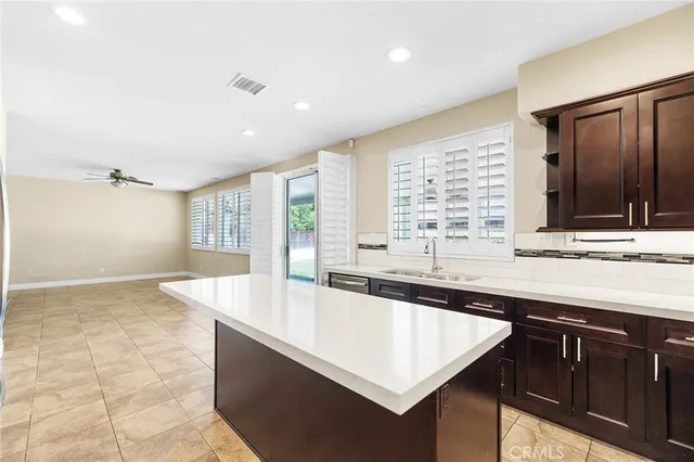 a large white kitchen with granite countertop a sink and a large window