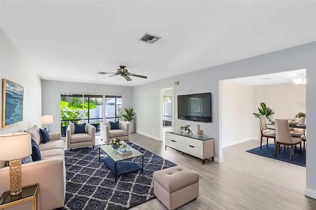 a living room with furniture flat screen tv and a large window