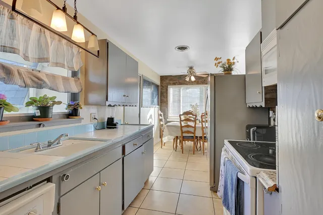 a kitchen with granite countertop a sink stove and cabinets