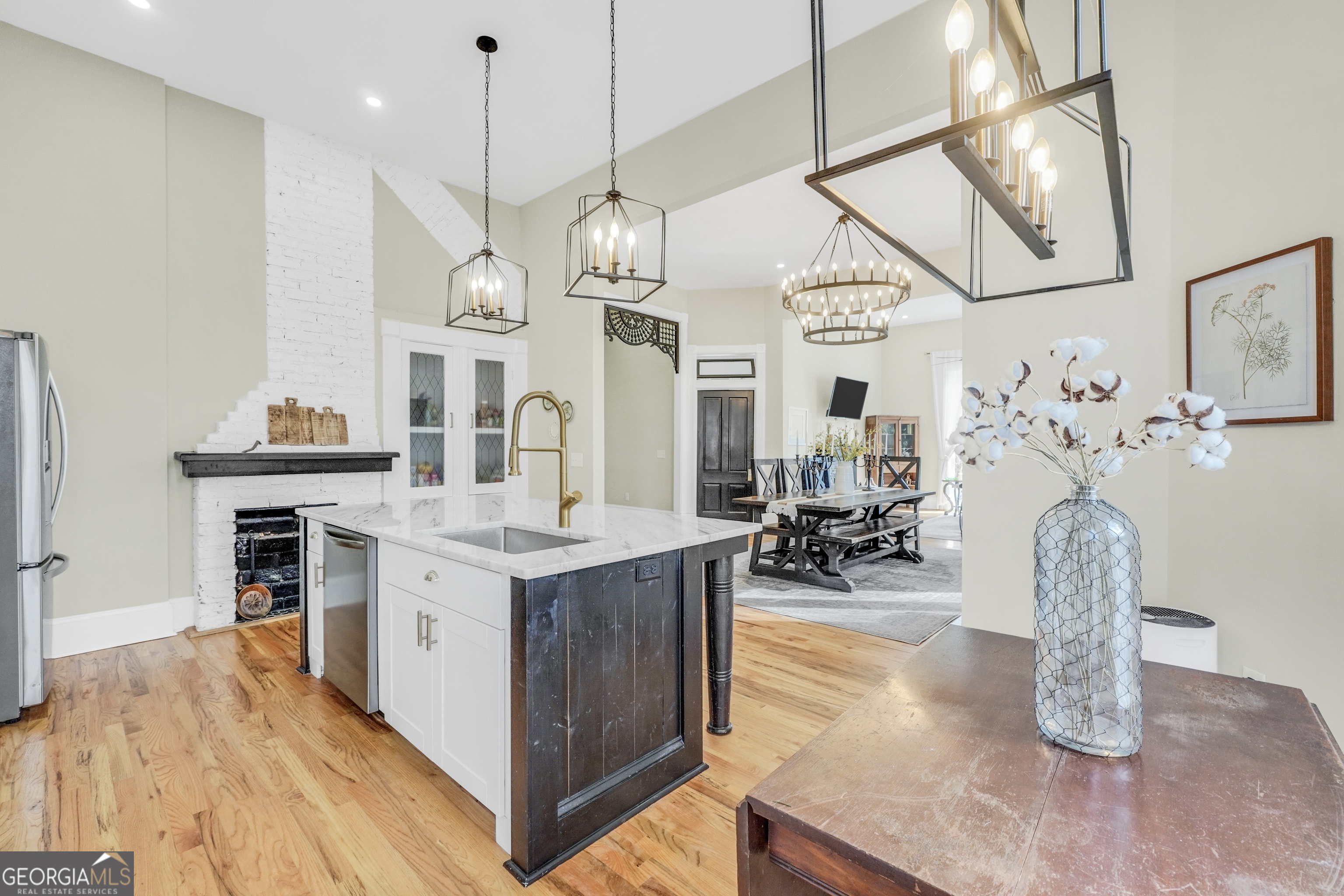 263 Julia Street Monticello, GA 31064 - Photo 13 of 49 a kitchen with stainless steel appliances granite countertop a sink dishwasher and a fireplace with wooden floor