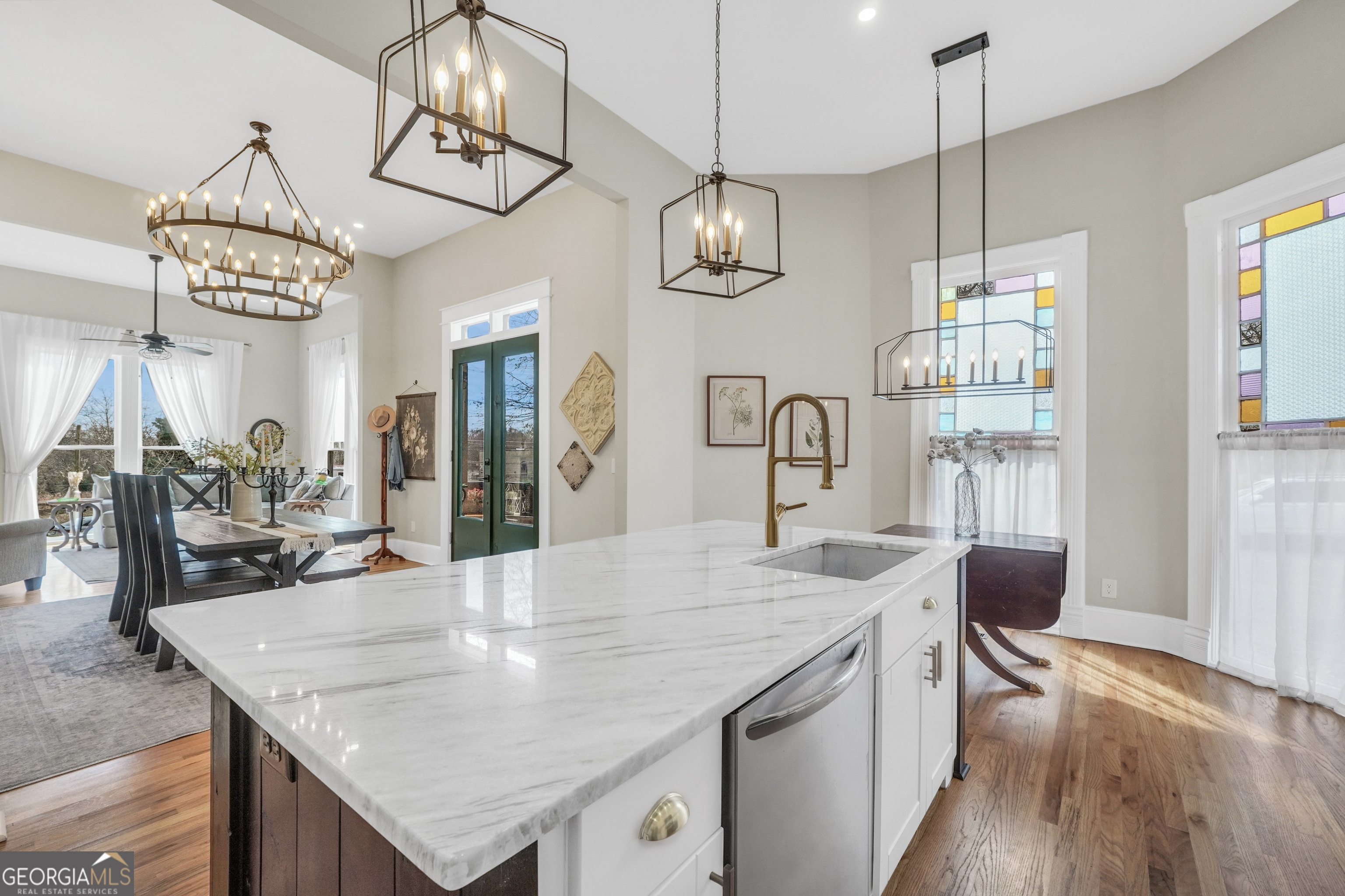 263 Julia Street Monticello, GA 31064 - Photo 15 of 49 a kitchen with stainless steel appliances granite countertop living room and kitchen chandelier