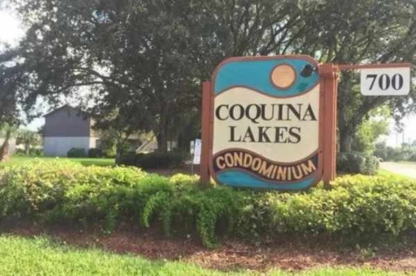 a sign broad in front of a tree