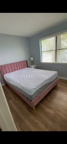 a bed sitting in a bedroom next to a window