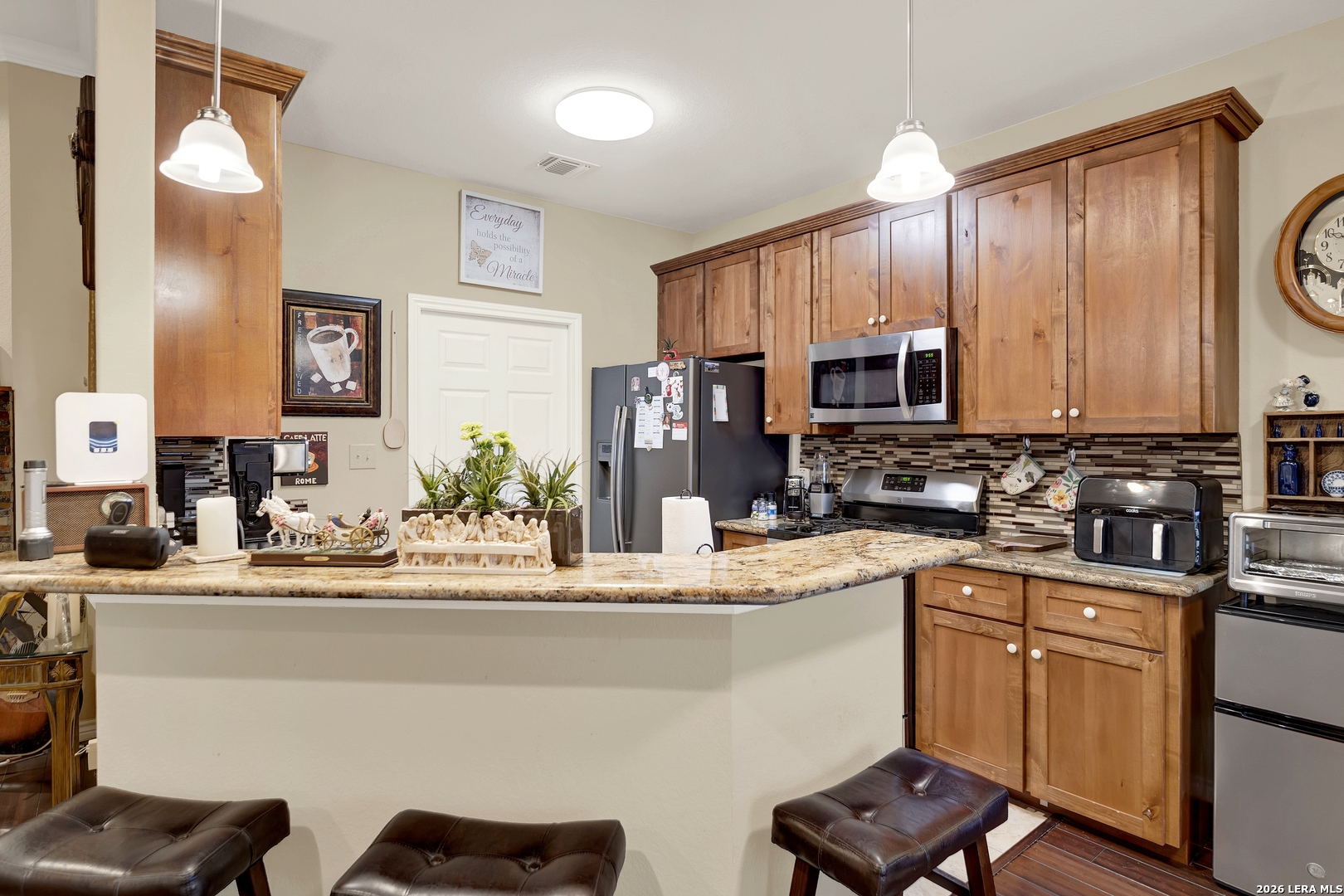 11669 Flores Avenue LaCoste, TX 78039 - Photo 22 of 36 a kitchen with stainless steel appliances granite countertop a sink stove and microwave