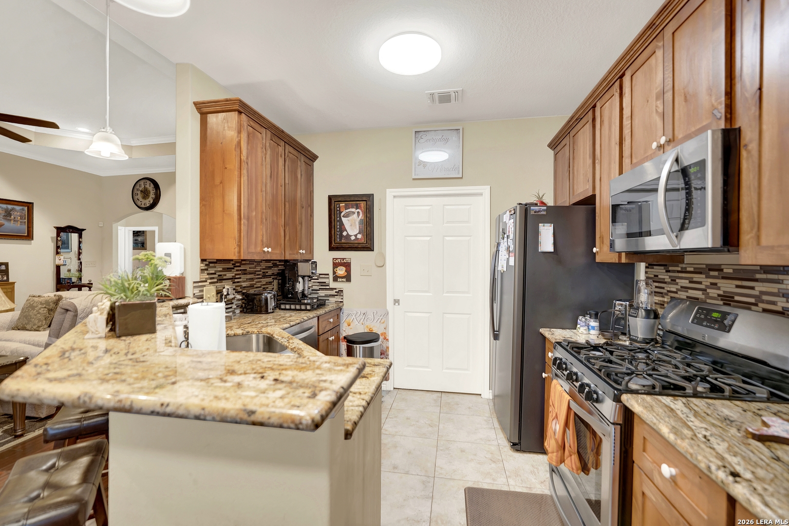 11669 Flores Avenue LaCoste, TX 78039 - Photo 24 of 36 a kitchen with stainless steel appliances granite countertop a stove a sink and a refrigerator