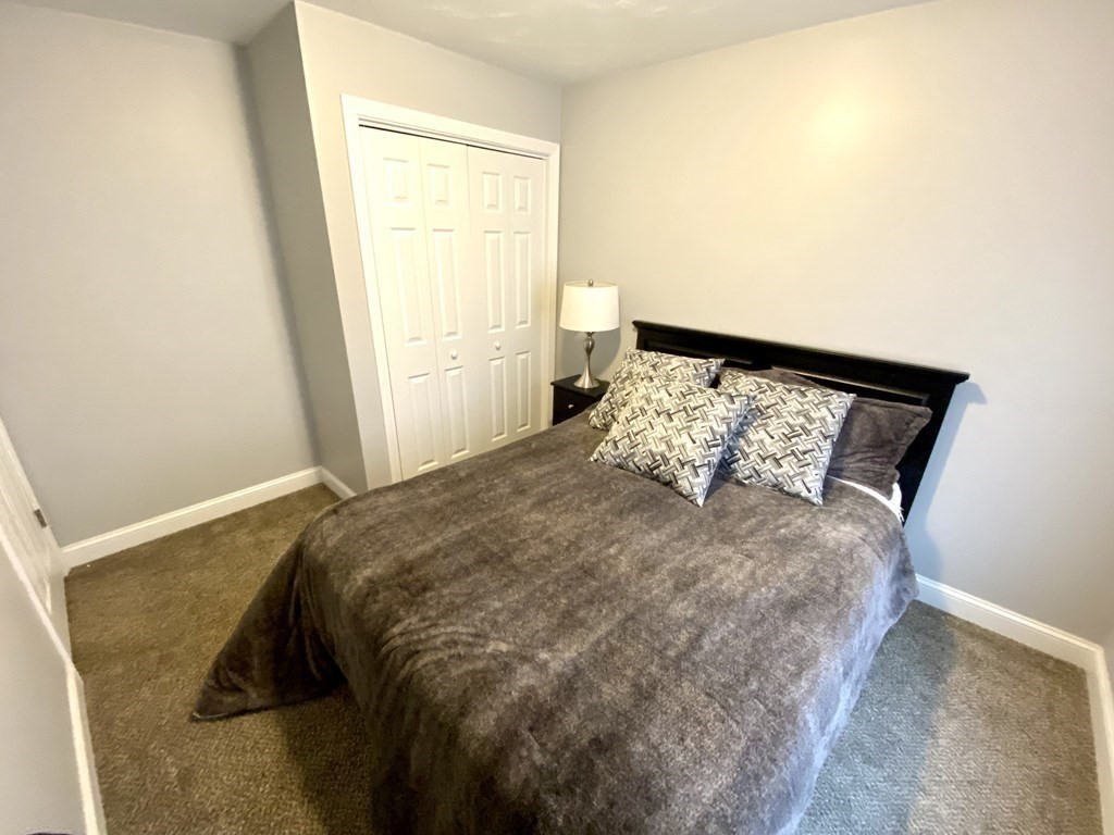 8 Mill Street, Unit B Wareham, MA 02576 - Photo 17 of 30 a large bed sitting in a bedroom next to a window