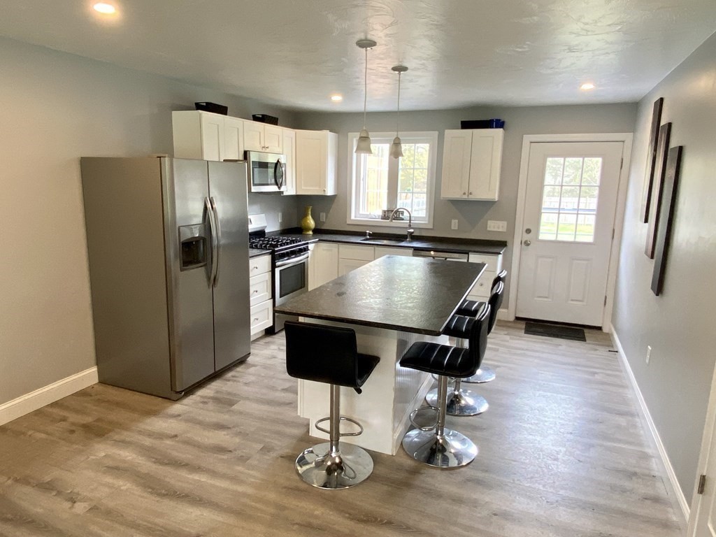 8 Mill Street, Unit B Wareham, MA 02576 - Photo 8 of 30 a kitchen with stainless steel appliances granite countertop a refrigerator stove top oven and cabinets