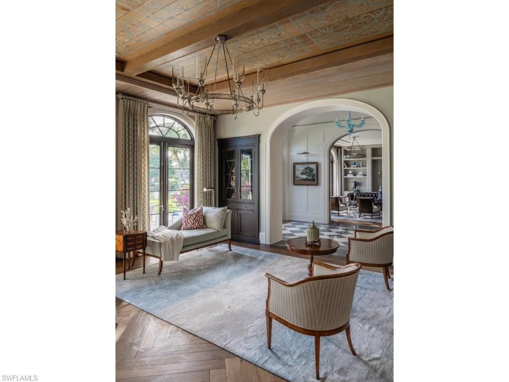 4296 Cutlass Lane Naples, FL 34102 - Photo 13 of 35 a living room with furniture and a chandelier