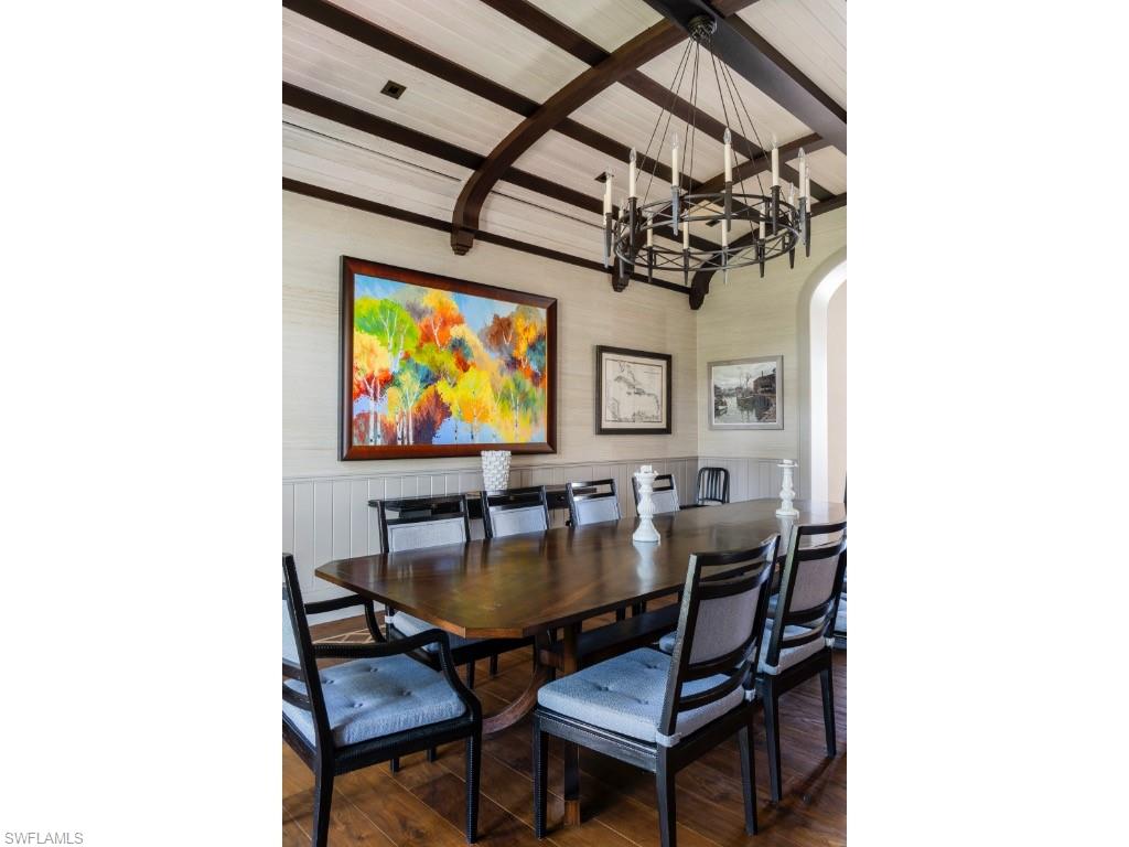 4296 Cutlass Lane Naples, FL 34102 - Photo 18 of 35 a dining room with furniture and a flat screen tv