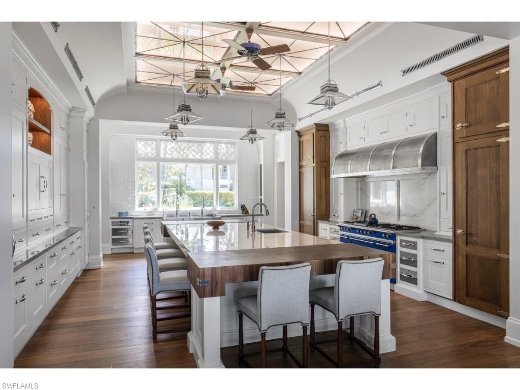 4296 Cutlass Lane Naples, FL 34102 - Photo 20 of 35 a dining room with furniture a chandelier and wooden floor