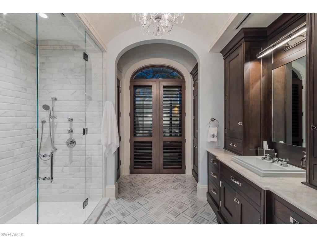 4296 Cutlass Lane Naples, FL 34102 - Photo 23 of 35 a bathroom with a granite countertop sink a mirror and shower