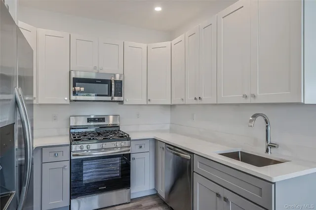 a kitchen with white cabinets and a stove top oven