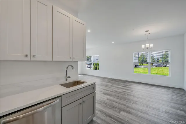 a kitchen with stainless steel appliances granite countertop a sink a stove and a wooden floors