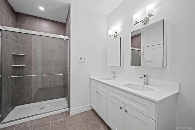 a bathroom with a shower sink and mirror