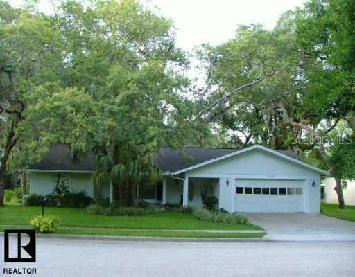 5509 Berkley Road New Port Richey, FL 34652 - Photo 1 of 1 a front view of a house with a garden and trees