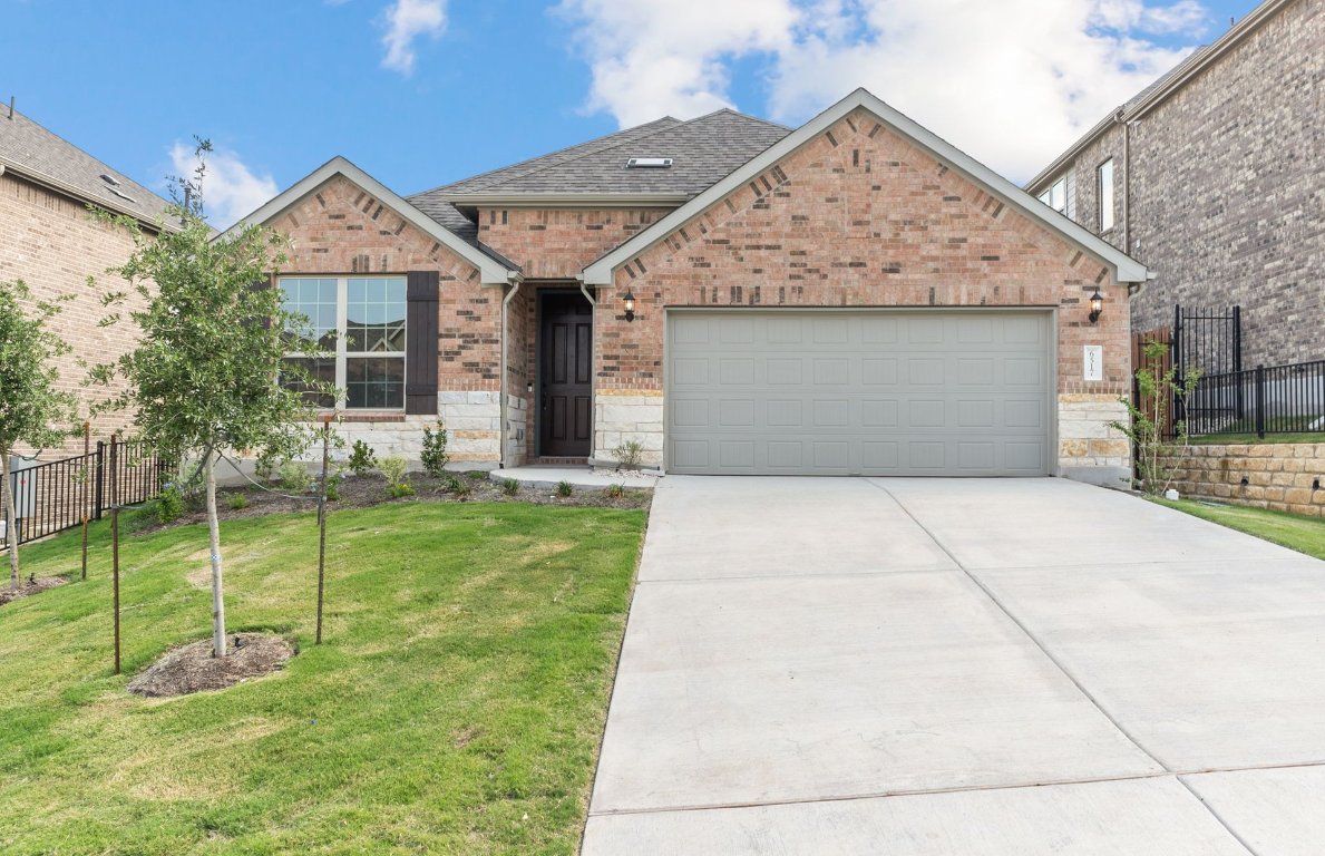 a front view of a house with a yard and garage