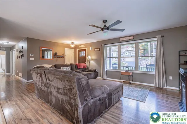 a living room with furniture a two couches and a large window