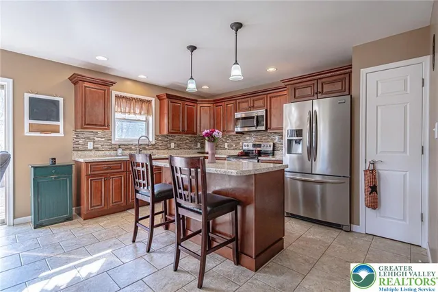 a kitchen with refrigerator a sink and chairs