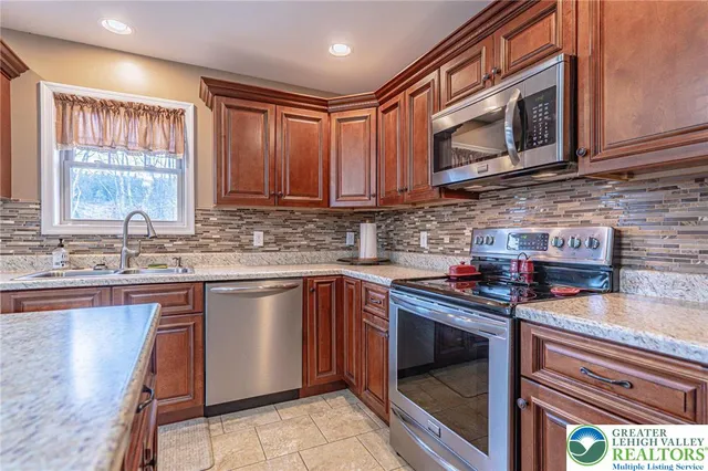 a kitchen with stainless steel appliances granite countertop a stove sink microwave and cabinets