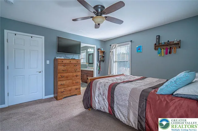 a bedroom with a bed a dresser and a chandelier