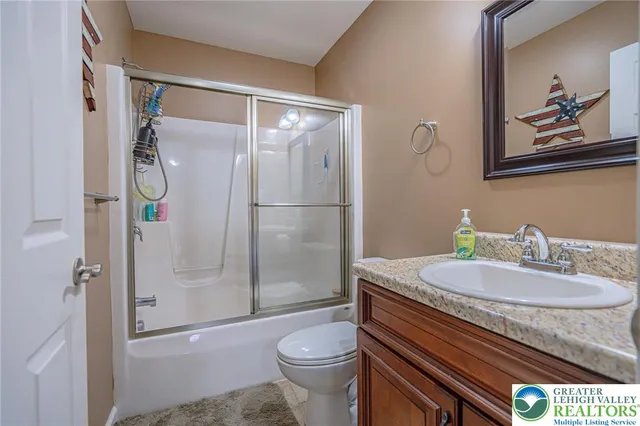 a bathroom with a granite countertop sink toilet and shower