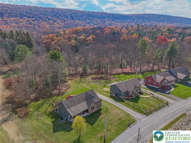 an aerial view of a house with a garden and lake view