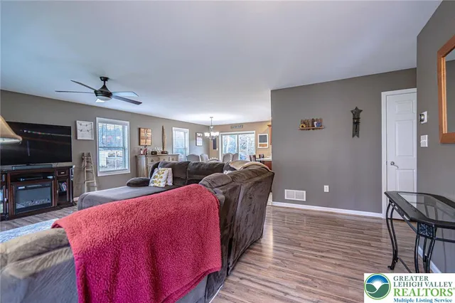 a living room with furniture a flat screen tv and kitchen view