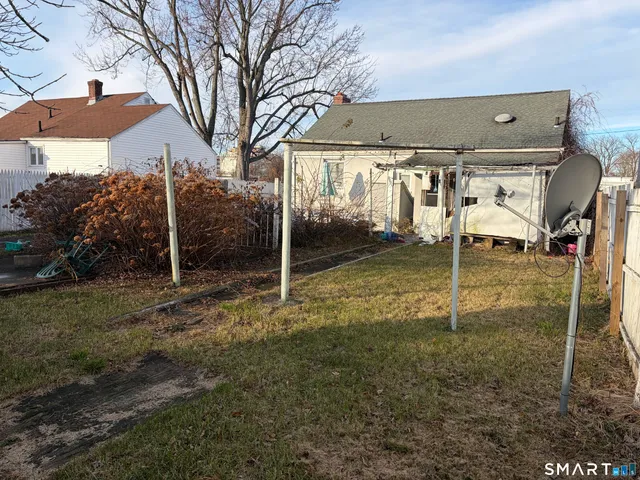 a view of a house with backyard and trees