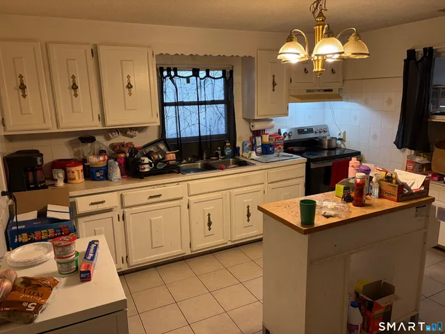 a kitchen with a sink dishwasher and white cabinets