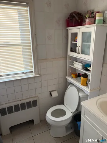 a bathroom with a toilet a sink and a window