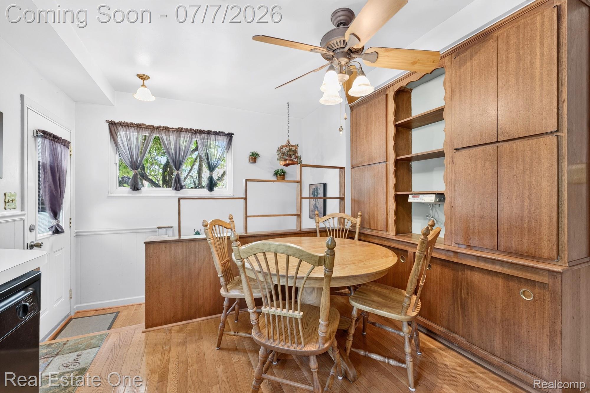 24749 Munson Street Taylor, MI 48180 - Photo 9 of 28 Built-in wood cabinetry with open shelving and storage, wood-finish flooring, ceiling fan with integrated lighting, and white paneled walls
