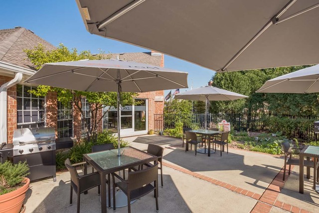 1681 East Greenbriar Drive, Unit 3818 Schaumburg, IL 60173 - Photo 24 of 26 a patio with a patio table and chairs under an umbrella