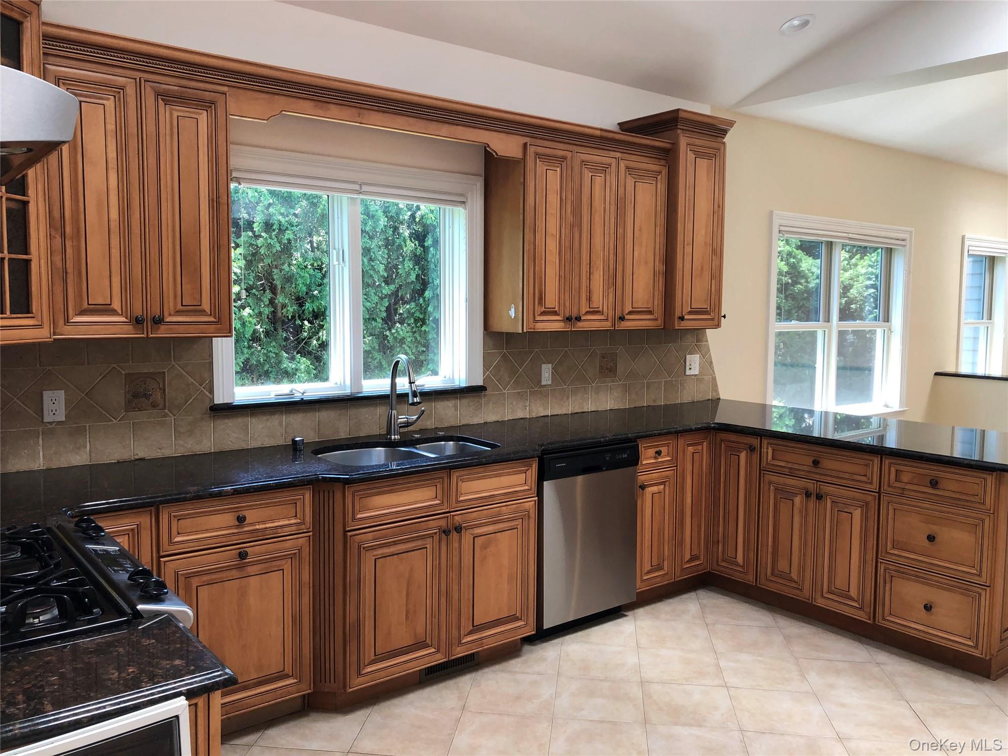 18 Crosshill Road Eastchester, NY 10709 - Photo 4 of 10 a kitchen with stainless steel appliances granite countertop a sink a stove and a microwave