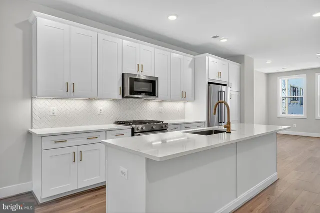a kitchen with white cabinets and appliances