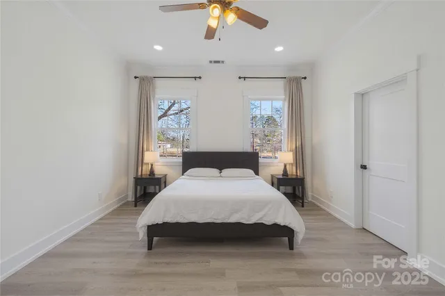 a spacious bedroom with a large bed and a chandelier