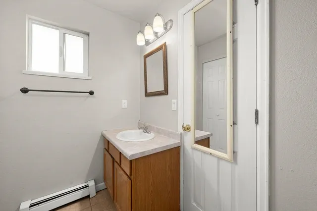 a bathroom with a sink a light fixture and a mirror