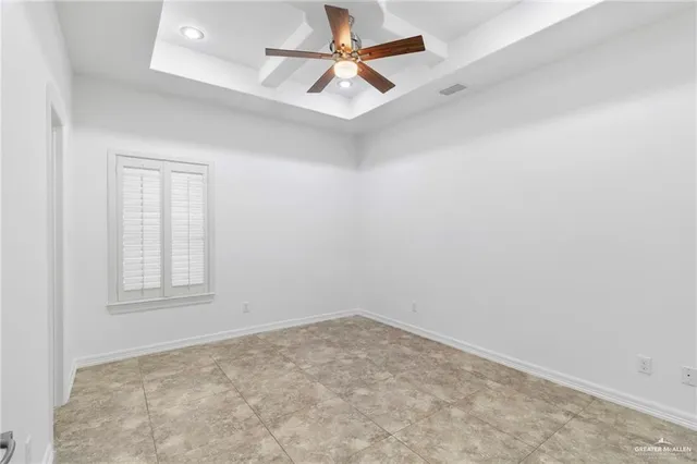 an empty room with a window and a fan