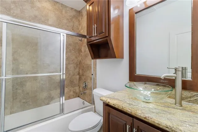 a bathroom with a granite countertop shower and a sink