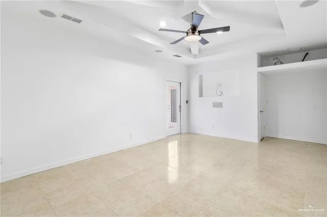 a view of an empty room with a ceiling fan