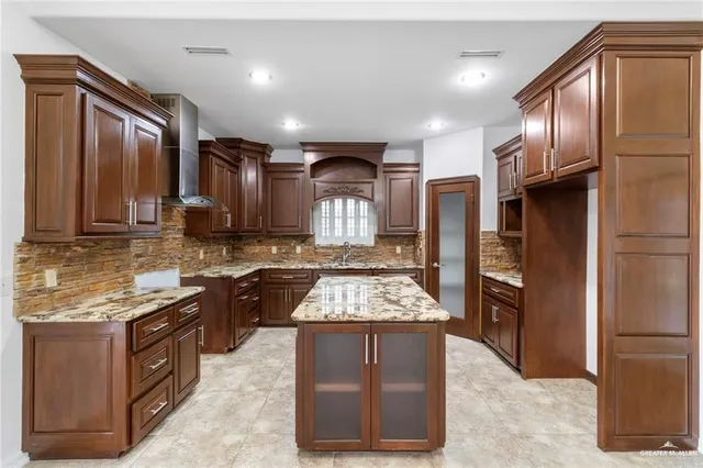 a kitchen with stainless steel appliances granite countertop a refrigerator a stove and a sink